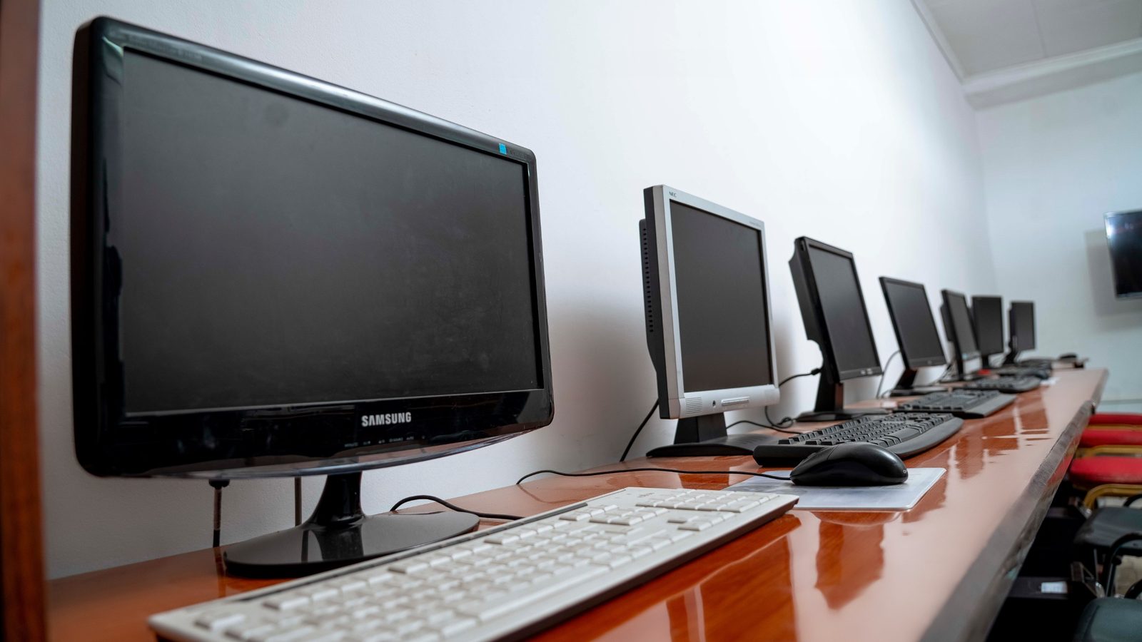 Rangée de postes informatiques en salle de cours